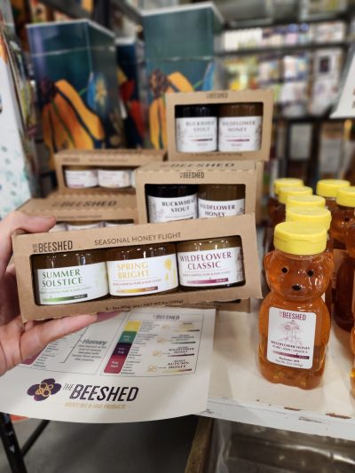 The Bee Shed Sampler pack being held with honey bottle next to it