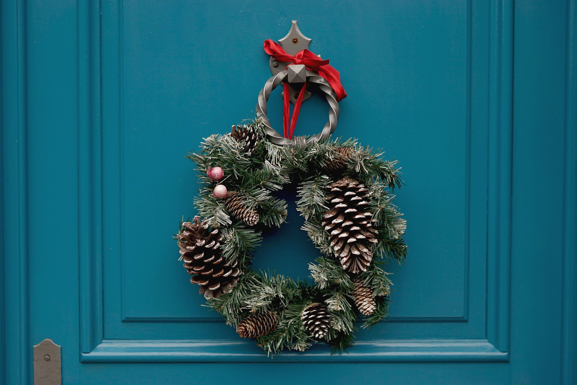 wreath with pines and red ribbon to show decorating front door