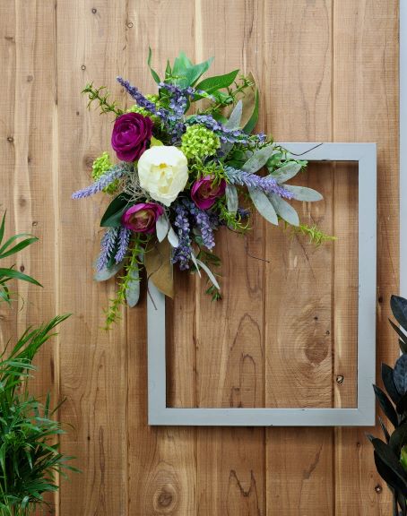 faux flower arrangement on the top left of a picture frame.